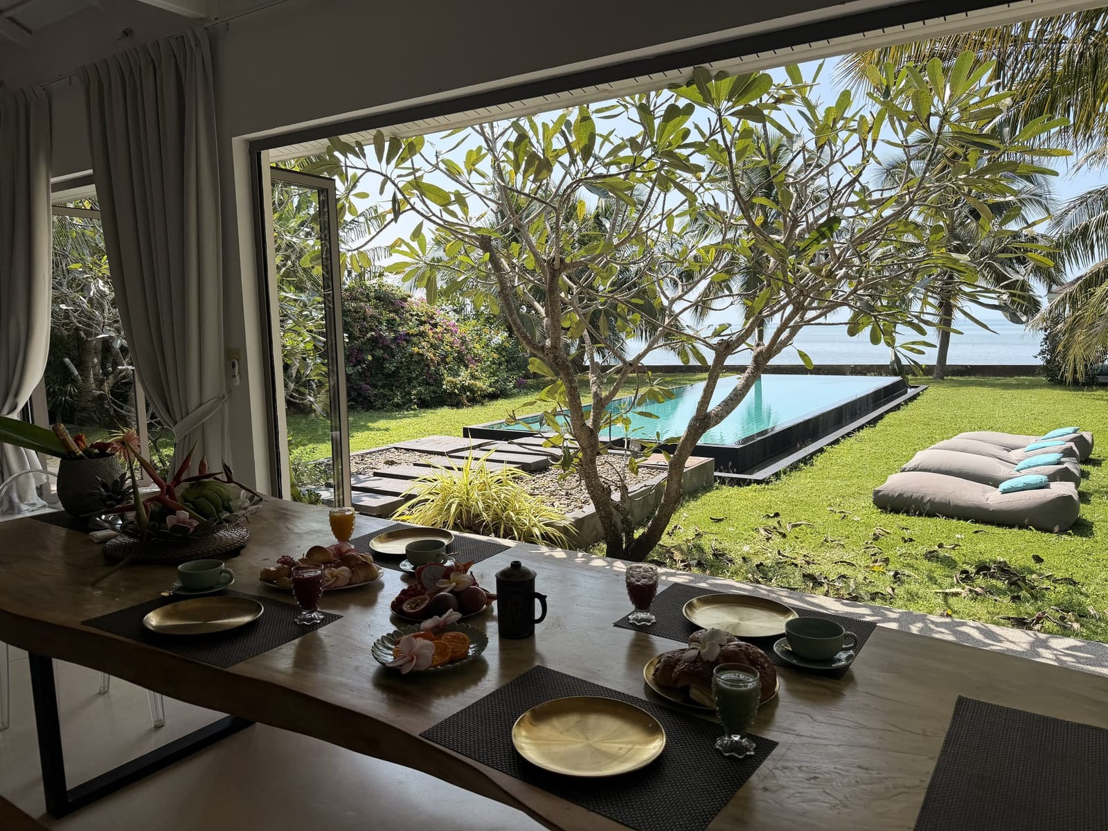 Dining table with garden and pool views at Villa Samui Cao