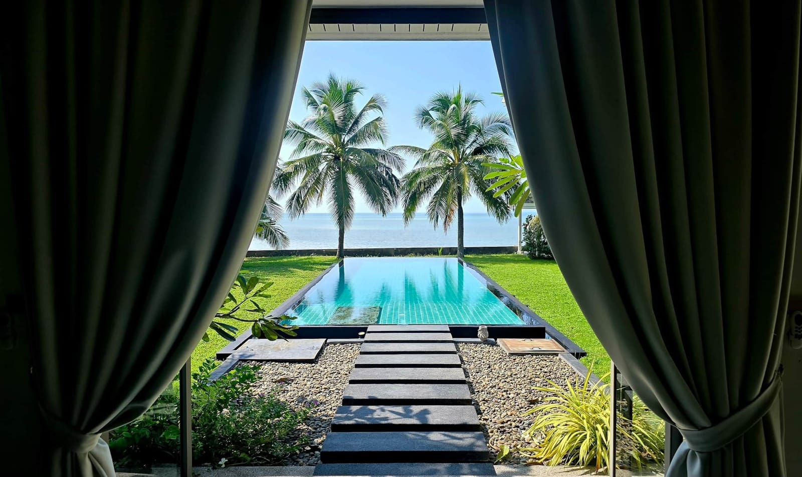 Pool and sea seen through the open doors at Villa Samui Cao