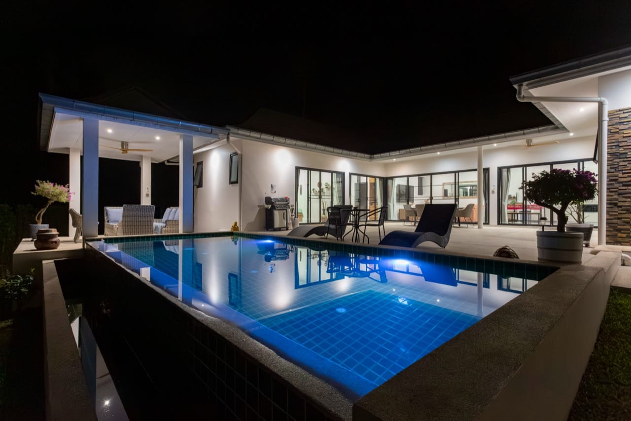 สระว่ายน้ำและระเบียงของ Villa International ในเวลากลางคืน